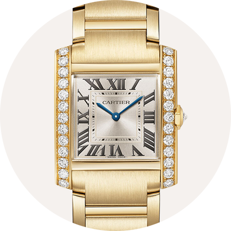Montre Tank de Cartier en or jaune sur un fond beige.